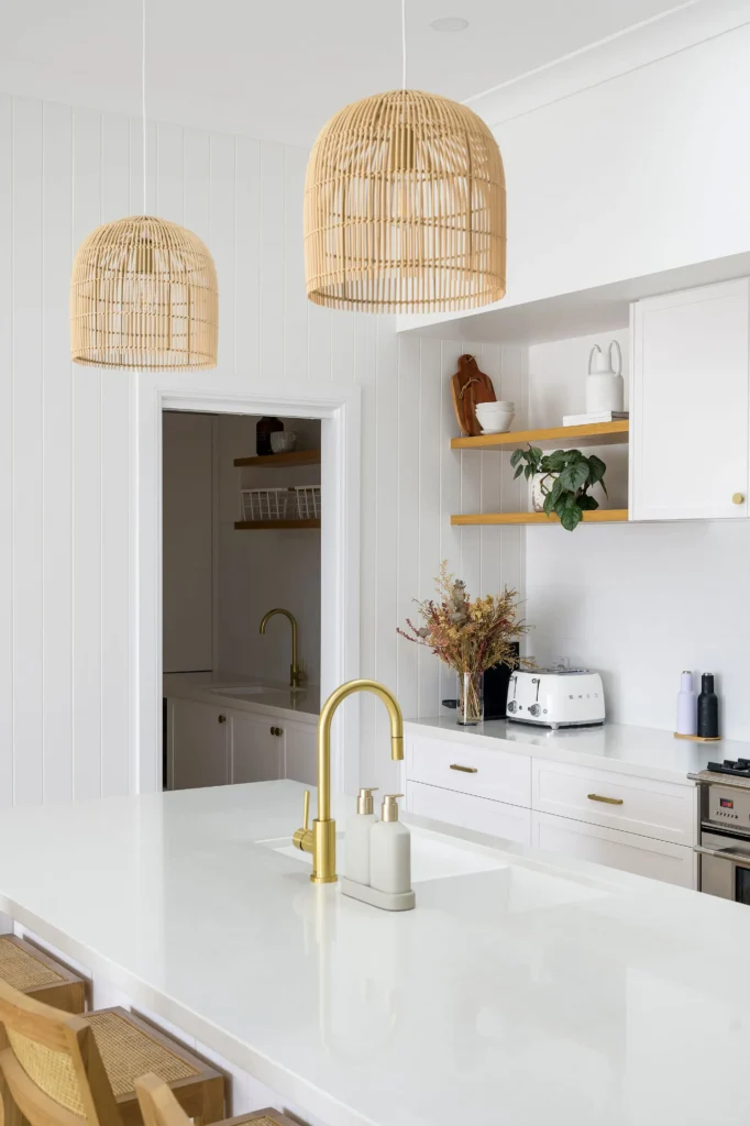 Kitchen with white cabinets and benchtop and timber feature lights