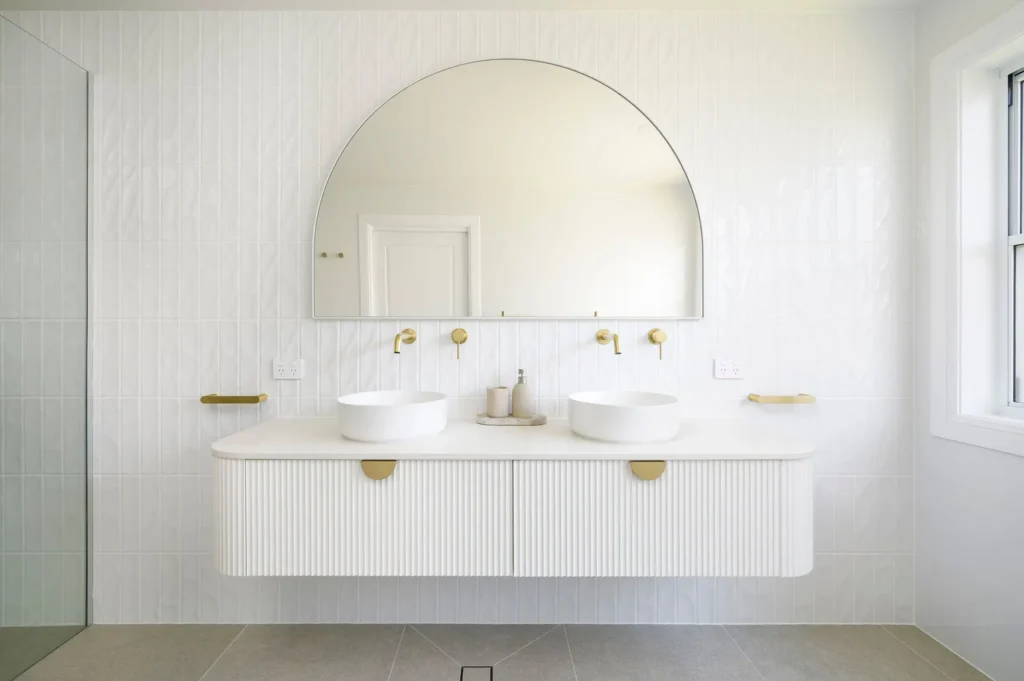 Elegant bathroom with arched mirror and white vanity